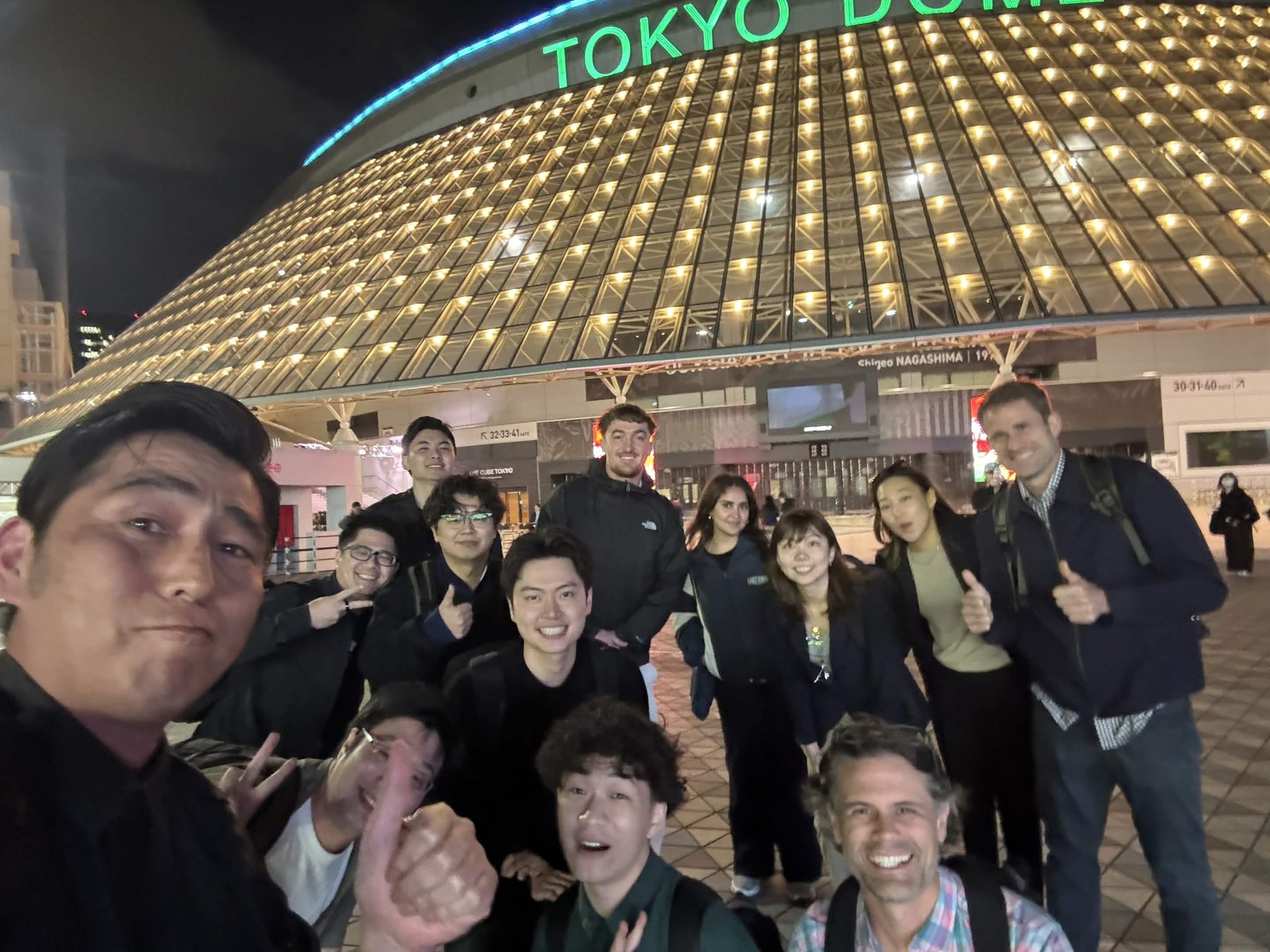 OpenDome founders gathered outside Tokyo Dome City at night